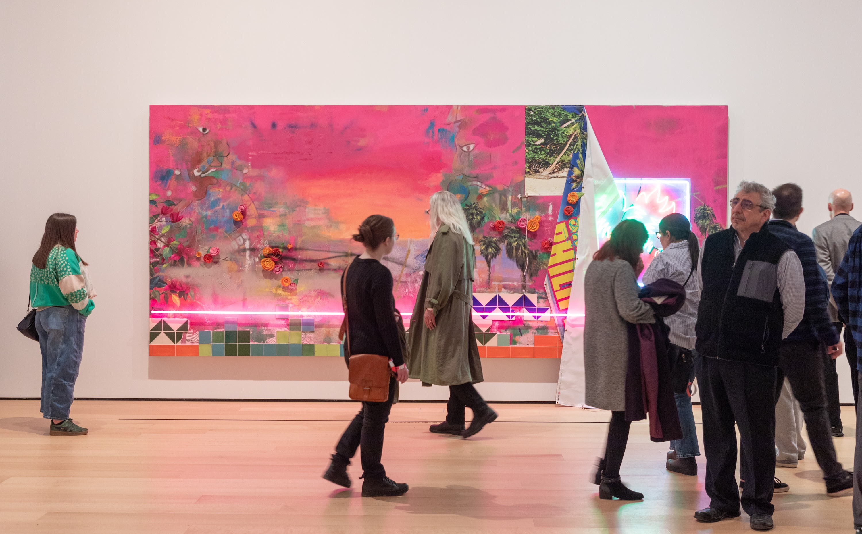 Visitors walking past a vibrant artwork