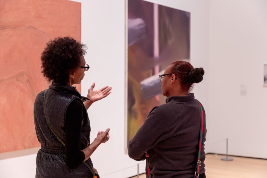 Two women in conversation in an art gallery