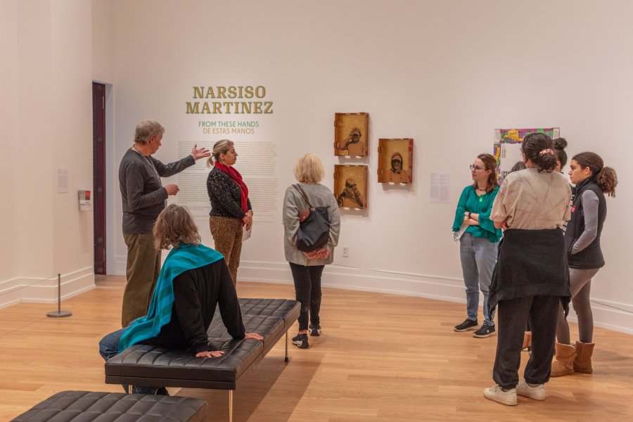 A docent leading a group tour in an art gallery